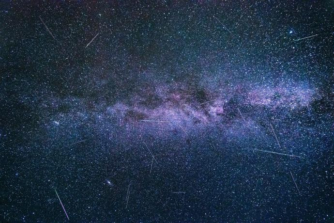 Sternhimmel mit Milchstraße in violetten Tönen. Sternschnuppen sind überall verteilt. Bild © Felix Mittermeier.