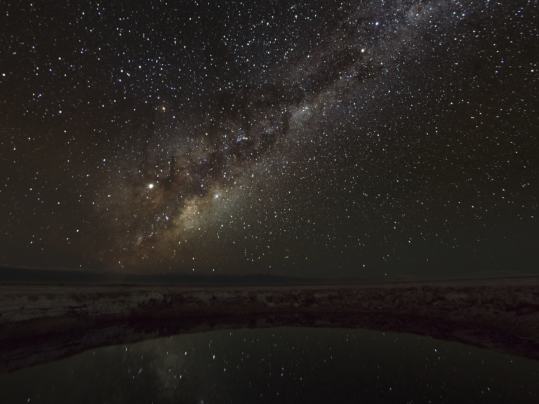Das Zentrum der Milky Way Galaxie steigt über der chilenischen Landschaft empor und wird im Gewässer des Ojos de Salar in der Atacama Wüste reflektiert. 