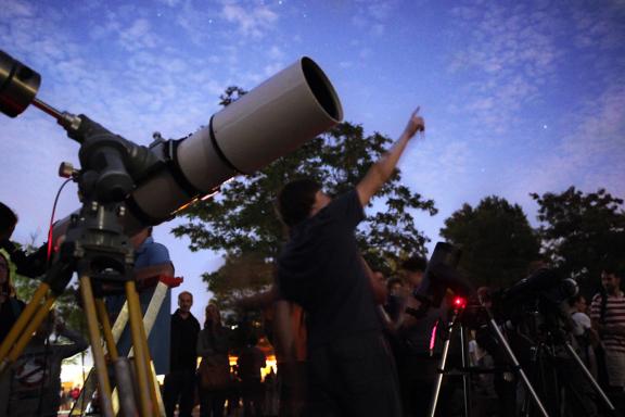 Teleskop mit Menschen und Nachthimmel